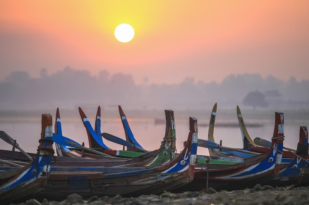 Colorful boats on the shore with sunrise near U Bein Bridge, Taungthaman Lake near Amarapura, Myanmar