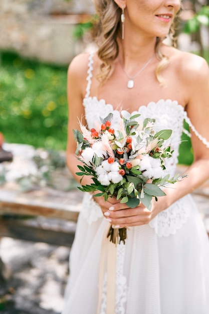 Colorful bouquet of flowers in the hands of the bride cropped