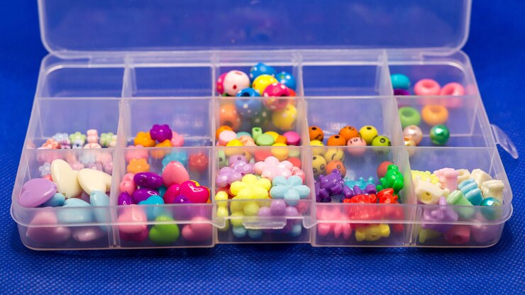 青い背景のプラスチック箱に彩色な明るい仕掛け物を縫製する