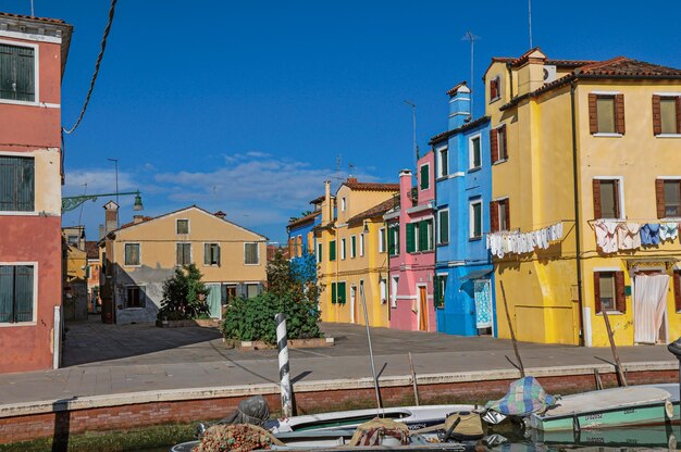 Foto edifici colorati e barche di fronte a un canale a burano, una piccola città piena di canali in italia