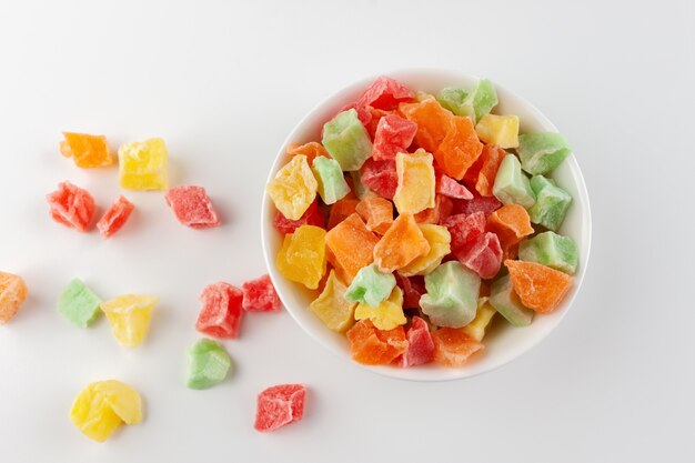 Colorful candied fruits in a white bowl isolated on white.