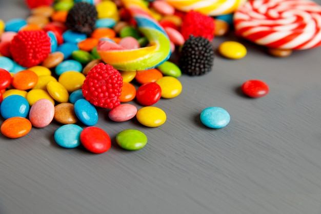 Colorful candies on a grey wooden table