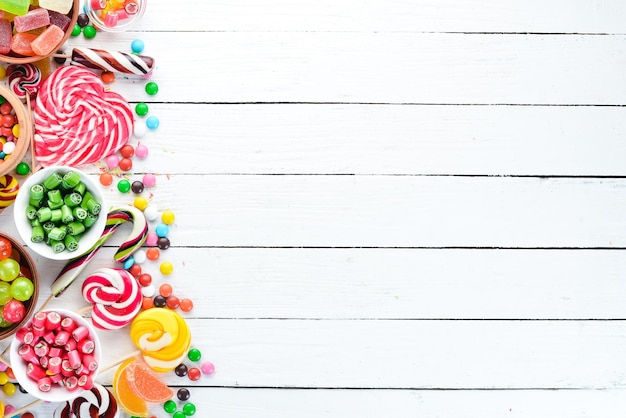 Colorful candies, jelly and marmalade on a white wooden background. Sweets. Top view. free copy space.