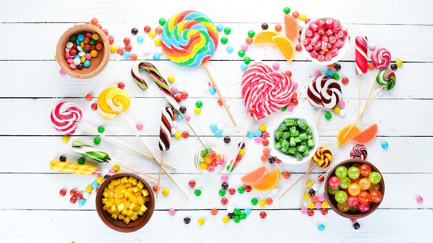 Colorful candies jelly and marmalade on a white wooden background Sweets Top view free copy space