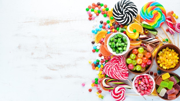 Colorful candies jelly and marmalade on a white wooden background Sweets Top view free copy space