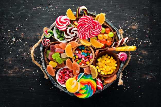 Photo colorful candies jelly and marmalade in a wooden box sweets on the old background top view free copy space