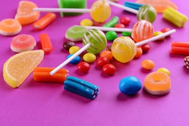 Colorful candies on purple background