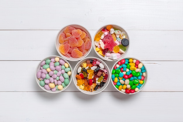 Photo colorful candies on wooden background