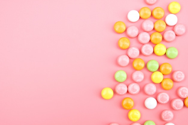 Photo colorful candy on pink background