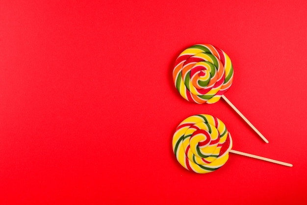 Colorful candy on a red  background. Lollipop. Top view. Copy space.