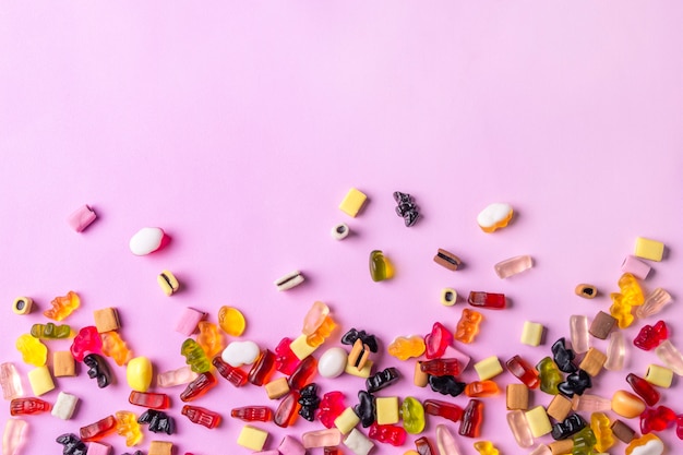 Colorful candy sweets on pink surface