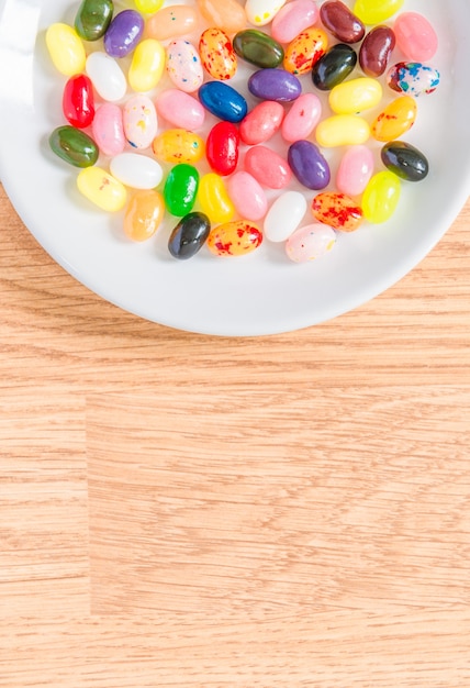 Разноцветные конфеты в белой тарелке