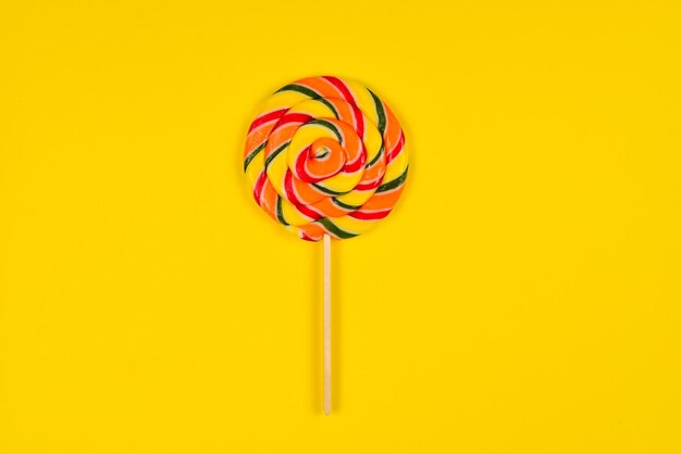 Colorful candy on a yellow  background Lollipop Top view Copy space