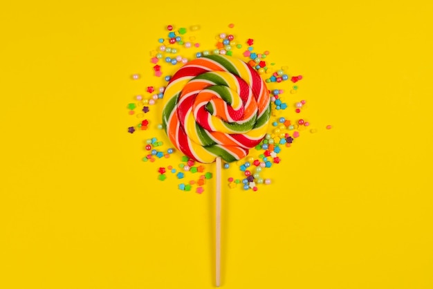 Colorful candy on a yellow background Lollipop Top view Copy space