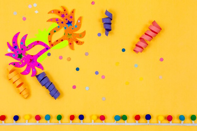 Photo colorful carnival mask adorned with confetti and streamers on a yellow background