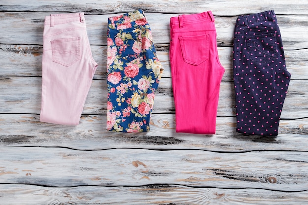 colorful casual trousers. folded pants of bright color. girl&amp;#39;s brand new summer pants. wooden showcase with popular items.