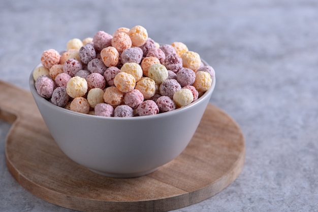 Colorful cereal corn balls mix fruit flavor bowl sweets on gray cement table