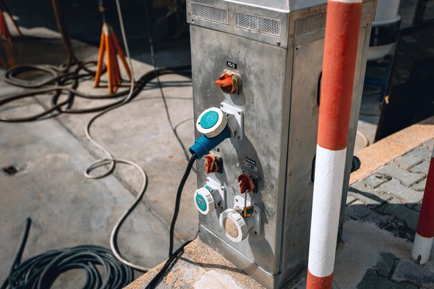 Colorful charging station for boats, electrical outlets to charge ships in harbor against many cords