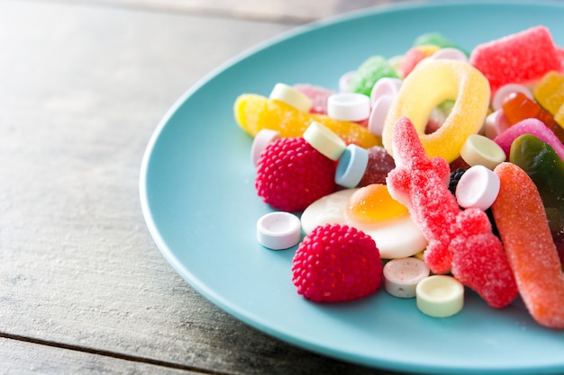 Colorful childs sweets and treats in plate on wooden table