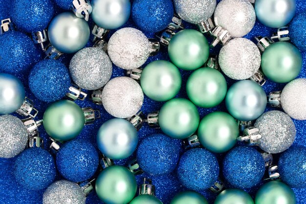 Colorful Christmas balls on a blue glittering background