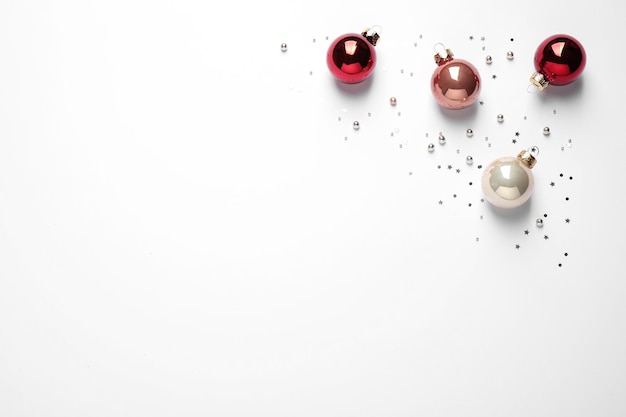 Colorful Christmas balls and sparkles on white background top view Space for text