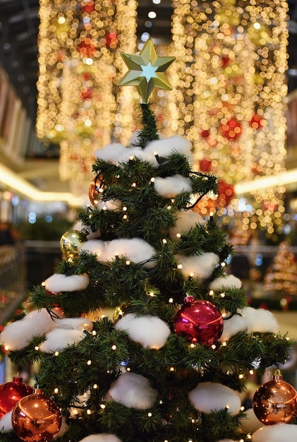 Decorazione colorata di natale. vacanze invernali e ornamenti tradizionali su un albero di natale. catene di illuminazione-bulbi per sfondo stagionale.