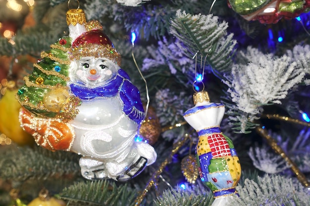 Foto figurine natalizie colorate uomini di neve su un albero di natale