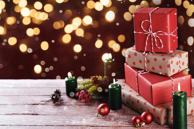 木製のテーブルの上に色とりどりのクリスマスプレゼントとろうそく