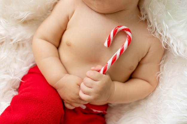 화려한 크리스마스 트리 모양의 어린이 손에 사탕
