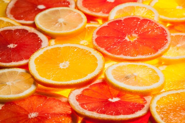 Colorful citrus fruit lemon orange grapefruit slices background Backlit