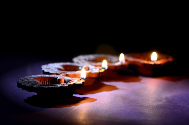 Diwali 축제 기간 동안 화려한 점토 Diya (랜턴) 램프가 켜집니다. 인사말 카드 디자인 Diwali라는 인도 힌두 빛 축제.