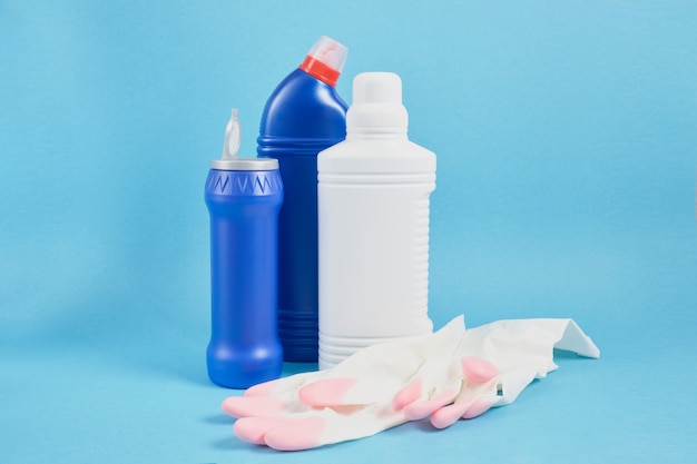 Colorful cleaning set for different surfaces in kitchen, bathroom Cleaning service and spring cleaning concept. copy space blue background sponge, gloves and detergent bottles