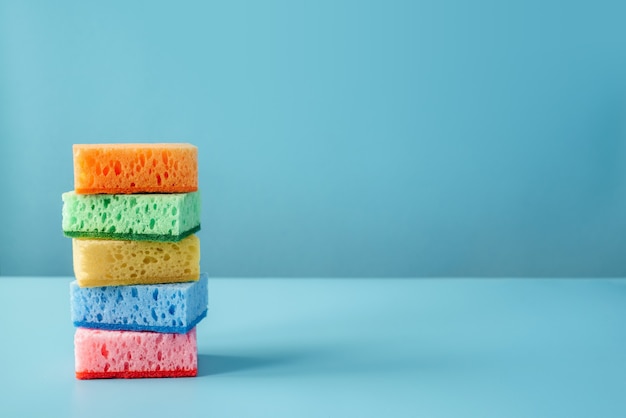 Colorful cleaning sponges on blue wall cleaning supplies cleaning service