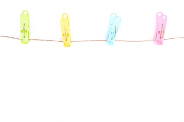 Colorful clothes pins on rope isolated on white