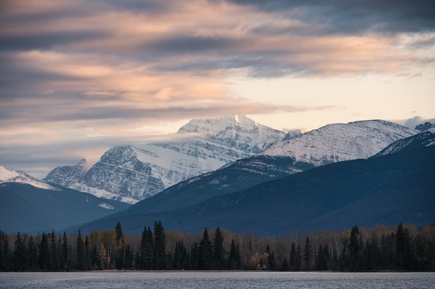 Colorful cloud flowing through rocky mountain on evening