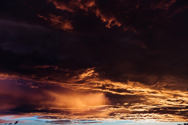 夕方の空に浮かぶ色とりどりの雲と暗い雲に輝く太陽の光