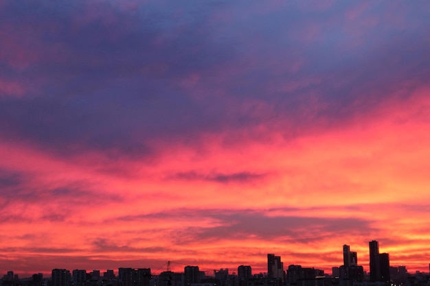 カラフルな曇りの夕暮れの美しい空の街並みの夕日と朝の日の出劇的な夕方の夜