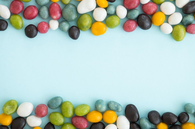 파란색 배경에 흩어져 있는 다채로운 코팅된 초콜릿 사탕