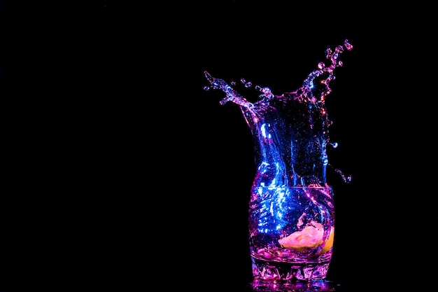 Colorful cocktail in glass with splashes and lemon on dark background party club entertainment mixed