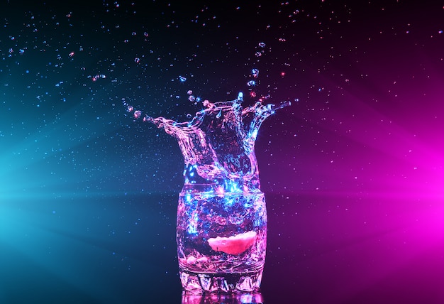 Colorful cocktail in glass with water splashes