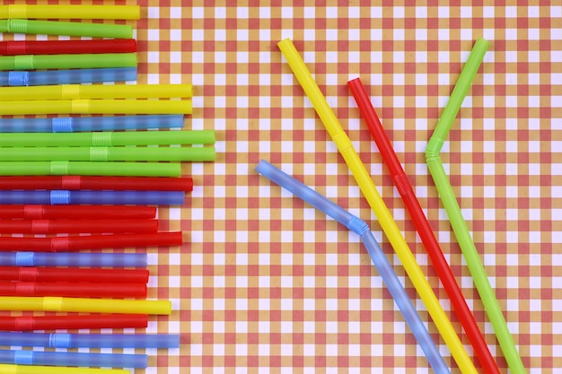 Photo colorful cocktail tubes lie on a bright color background