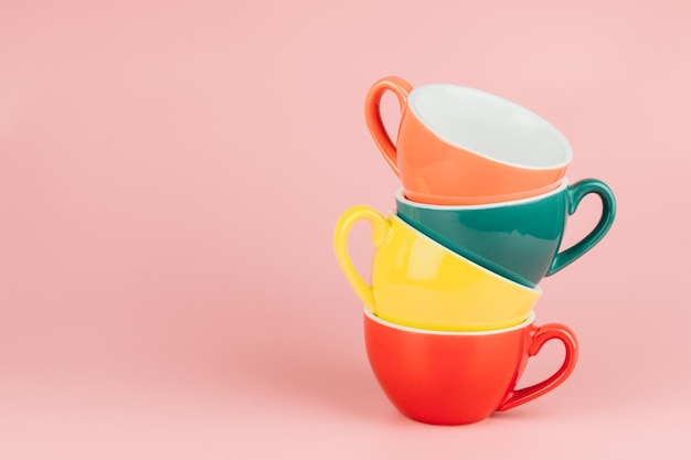 ピンクの背景に色とりどりのコーヒーカップ