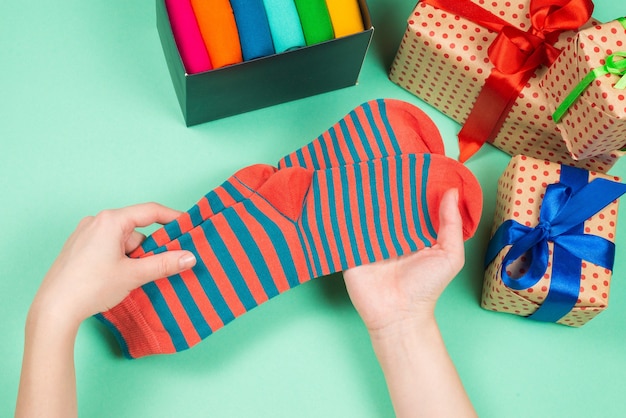 Collezione colorata di calze di cotone come regalo nelle mani di una donna. regalo.