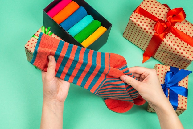 Colorful collection of cotton socks as a gift in woman hands