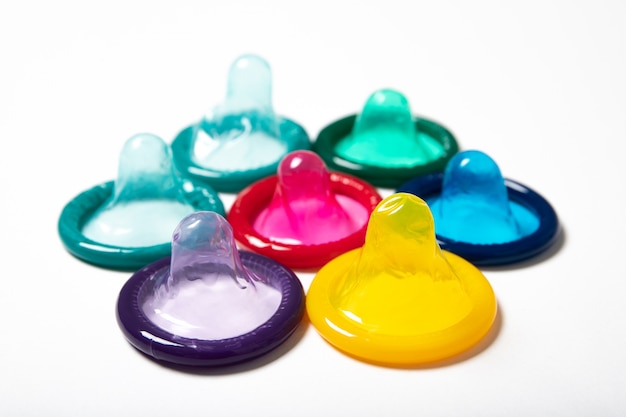 Colorful condoms on white background