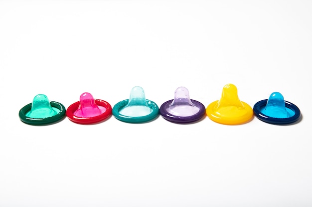 Colorful condoms on white background