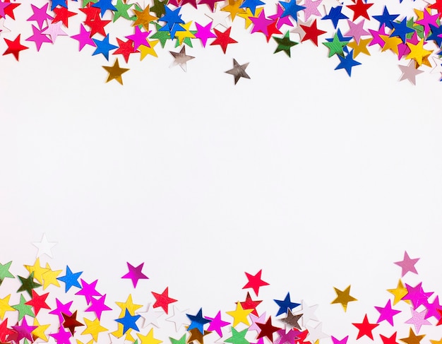 Photo colorful confetti in the shape of a star scattered on a gray background