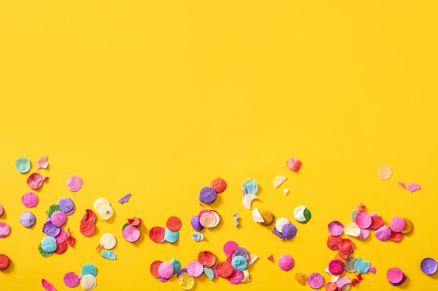 Colorful confetti on yellow background.