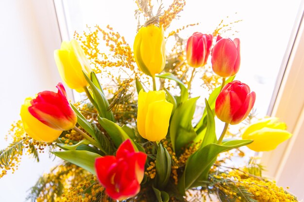 チューリップとミモザのカラフルなお祝いの春の花束。小さなフォーカスが選択されました。