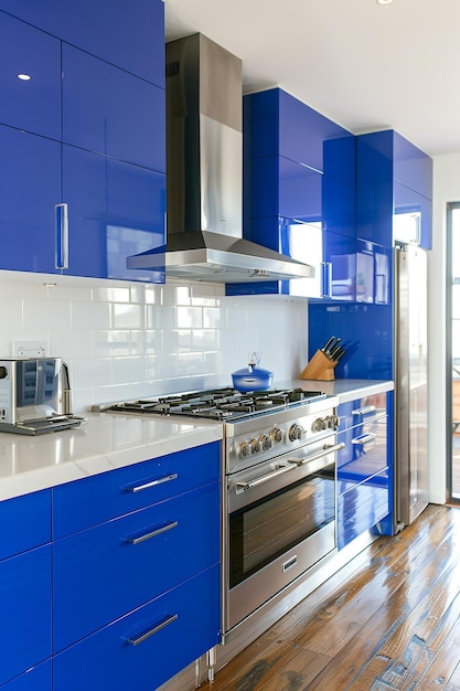 A colorful contemporary kitchen with bright blue cabinets and sleek stainless steel appliances set against a backdrop of white walls with copy space